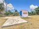 View of a PODS storage container on a concrete pad, situated in a grassy yard with a chain-link fence at 14034 Water Tower Dr, Hudson, FL 34667
