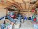 Messy shed interior packed with equipment, tools, and storage boxes with an exposed rafter ceiling at 14034 Water Tower Dr, Hudson, FL 34667