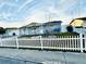 Cozy home with a white picket fence, a well-kept lawn and beautiful blue skies at 1415 Weyford Ln, Holiday, FL 34691