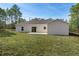 Backyard featuring a well-maintained lawn, patio, and the back of a stucco home under a bright sky at 16434 Medley Rd, Weeki Wachee, FL 34614