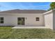 Backyard view showcasing the home's stucco exterior, patio, and well-maintained lawn in a serene setting at 16434 Medley Rd, Weeki Wachee, FL 34614