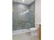 Tiled bathroom shower with glass door and gold trim, white toilet, and part of a wooden vanity at 16434 Medley Rd, Weeki Wachee, FL 34614