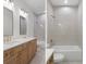 Modern bathroom featuring double sinks, sleek mirrors, and a stylish shower-tub combination with decorative tile at 16434 Medley Rd, Weeki Wachee, FL 34614