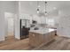 Bright, open kitchen features an island, stainless steel appliances, white cabinets, and hardwood floors at 16434 Medley Rd, Weeki Wachee, FL 34614
