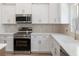 Well-equipped kitchen featuring stainless steel appliances, modern cabinets, granite countertops, and a stylish backsplash at 16434 Medley Rd, Weeki Wachee, FL 34614