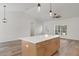 Spacious kitchen with a large island, modern pendant lighting, and hardwood floors, seamlessly flowing into living area at 16434 Medley Rd, Weeki Wachee, FL 34614