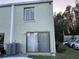Rear exterior view, showcasing sliding glass doors and AC unit at 1761 Cupecoy Cir # N-1, Lutz, FL 33558