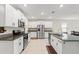 Open kitchen with white cabinets, granite countertops, and stainless steel appliances at 194 Argyll Dr, Spring Hill, FL 34609