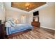 Primary bedroom with wood floors and a large TV at 20200 Lace Cascade Rd, Land O Lakes, FL 34637