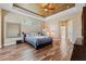 Bright Primary bedroom featuring wood floors and a tray ceiling at 20200 Lace Cascade Rd, Land O Lakes, FL 34637
