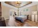 Spacious Primary bedroom with wood floors, tray ceiling, and large windows at 20200 Lace Cascade Rd, Land O Lakes, FL 34637