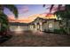 Luxury home with a gorgeous brick driveway, illuminated at dusk at 20200 Lace Cascade Rd, Land O Lakes, FL 34637