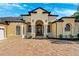 Elegant home exterior featuring a brick paver driveway and arched entryway at 20200 Lace Cascade Rd, Land O Lakes, FL 34637
