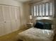 Bedroom featuring shutters, a floral print bedspread, a closet, and yellow carpet at 2718 Highlands Blvd # A, Palm Harbor, FL 34684