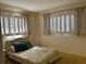 Bedroom featuring two windows with shutters, a floral print bedspread and yellow carpet at 2718 Highlands Blvd # A, Palm Harbor, FL 34684