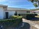 Landscaped front yard with lush greenery leading to the front entrance of the single-story home at 2718 Highlands Blvd # A, Palm Harbor, FL 34684