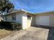 View of the home's exterior, highlighting the attached two-car garage and tidy landscaping at 2718 Highlands Blvd # A, Palm Harbor, FL 34684