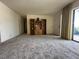 Open floor plan of carpeted living room with built-in shelving and access to other rooms at 2718 Highlands Blvd # A, Palm Harbor, FL 34684