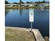 Warning sign at the pond edge indicates alligators present; no swimming or fishing is allowed at 2718 Highlands Blvd # A, Palm Harbor, FL 34684