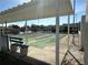 View of shuffleboard courts under a covered area with benches and pond in the background at 2718 Highlands Blvd # A, Palm Harbor, FL 34684