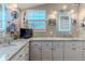 Bathroom with white cabinets, dual sinks, granite countertops, and illuminated mirrors at 3308 Oleander Dr, Hernando Beach, FL 34607