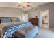 Comfortable bedroom featuring a patterned bedspread, tufted ottoman, and en suite bathroom at 3308 Oleander Dr, Hernando Beach, FL 34607
