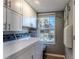 Bright laundry room features white cabinets, window with view, and side-by-side washer and dryer at 3308 Oleander Dr, Hernando Beach, FL 34607