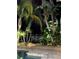 Night view of a poolside patio area with tropical landscaping at 3308 Oleander Dr, Hernando Beach, FL 34607