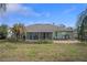 Green house exterior and backyard with patio, screened porch, and lush landscaping at 3497 Chadwick Ave, Spring Hill, FL 34609