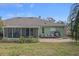 Spacious backyard with patio, screened porch, and lush landscaping at 3497 Chadwick Ave, Spring Hill, FL 34609