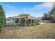 House exterior showcasing a large backyard with a screened patio at 3497 Chadwick Ave, Spring Hill, FL 34609