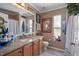 Bathroom with granite countertop, wood cabinets and shower at 3497 Chadwick Ave, Spring Hill, FL 34609