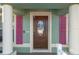 Elegant dark wooden front door with glass accents and pink shutters at 3497 Chadwick Ave, Spring Hill, FL 34609
