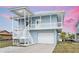 Inviting two-story coastal home featuring a spacious covered porch and convenient garage access at 4045 Centavo Ct, Hernando Beach, FL 34607