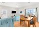 Bright living room featuring a dining table, sofa, and a view of the neighborhood through a sliding glass door at 4045 Centavo Ct, Hernando Beach, FL 34607