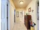 A well-lit hallway featuring tile flooring and wooden cabinet at 4061 Montano Ave, Spring Hill, FL 34609