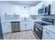 Modern kitchen boasts white shaker cabinets, stainless steel appliances, and quartz countertops at 4292 Maple Ne St, St Petersburg, FL 33703