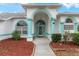 Front entrance with teal accents and arched entryway at 4438 Crescent Rd, Spring Hill, FL 34606