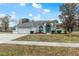 House exterior featuring a two-car garage and manicured lawn at 4438 Crescent Rd, Spring Hill, FL 34606