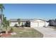 Single-story home with attached two-car garage and landscaped yard at 4949 Waterside Dr, Port Richey, FL 34668