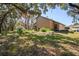 Tan house with brown roof, single-car garage, and landscaping at 541 Bent Oak Ct, Spring Hill, FL 34609