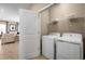 Convenient laundry room with washer, dryer, and overhead shelving at 6027 Wild Petunia Dr, Wimauma, FL 33598
