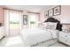 Stylish bedroom with a pink accent wall, a black headboard, and white bedding at 6033 Wild Petunia Dr, Wimauma, FL 33598