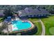 An aerial shot of the clubhouse and pool with lounge chairs and manicured green lawns at 6520 Pine Meadows Dr, Spring Hill, FL 34606
