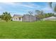 Expansive backyard featuring a screened-in lanai and lush green lawn at 6520 Pine Meadows Dr, Spring Hill, FL 34606