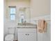 Bathroom features granite countertop, white cabinets and tile, and a window for natural light at 6520 Pine Meadows Dr, Spring Hill, FL 34606