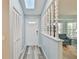 Bright entryway with wood-look floors, coat closet and decorative partition wall to living room at 6520 Pine Meadows Dr, Spring Hill, FL 34606