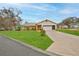 Well-maintained home with a lush green lawn, mature landscaping, and a two-car garage at 6520 Pine Meadows Dr, Spring Hill, FL 34606