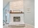 Cozy living room fireplace featuring a painted stone facade and rustic wood mantle at 6520 Pine Meadows Dr, Spring Hill, FL 34606