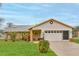 Charming single-story home featuring a well-manicured lawn, brick accents, and an attached two-car garage at 6520 Pine Meadows Dr, Spring Hill, FL 34606